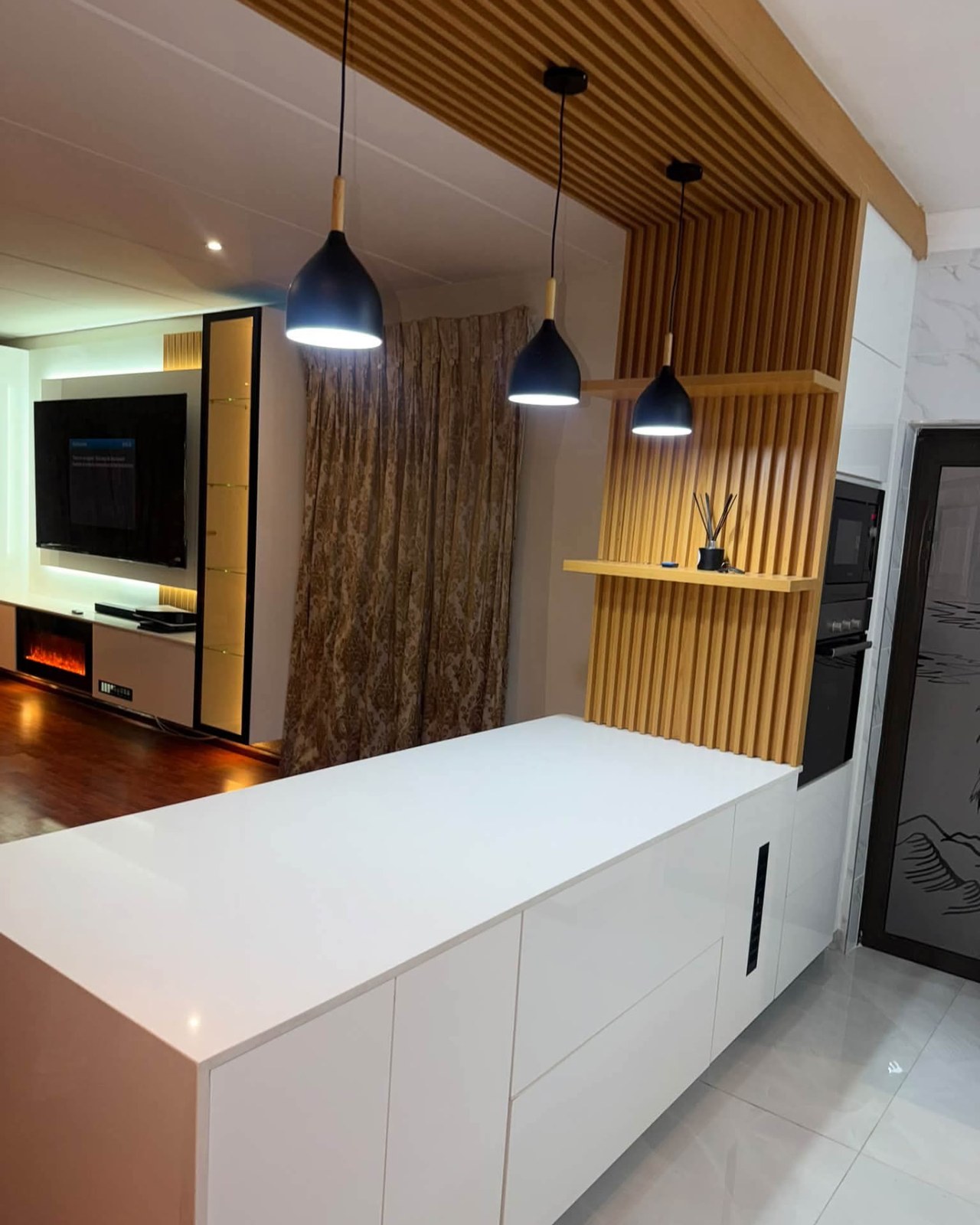 White breakfast island with fluted wood panelling and black pendant lights