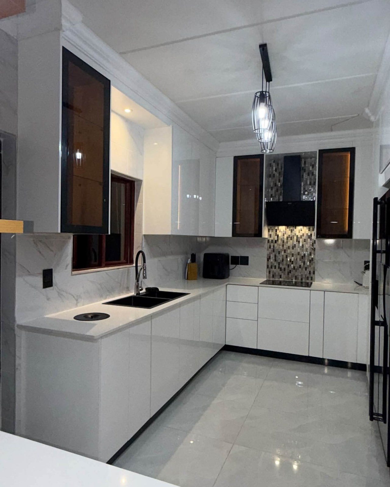 White kitchen with black-framed glass cabinets and black appliances