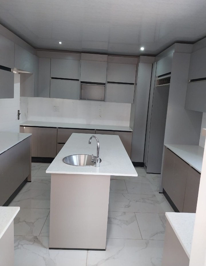 Neutral kitchen with island sink and marble-look floor